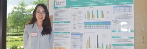 Lisa Ros-Choi standing next to her research poster