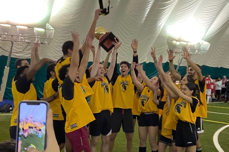A group of students cheering and celebrating a soccer game win