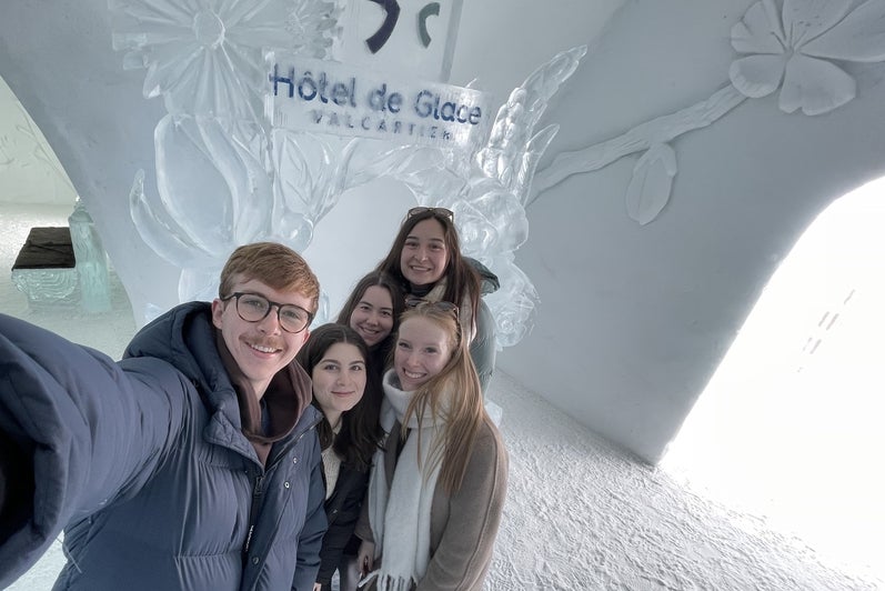 Students smiling in front of Hotel de Glase in Montreal