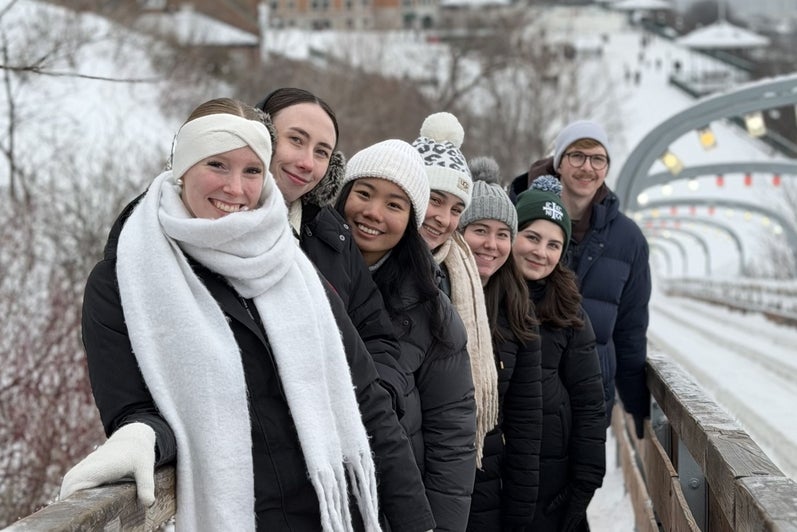 A group of students smiling on a bridge