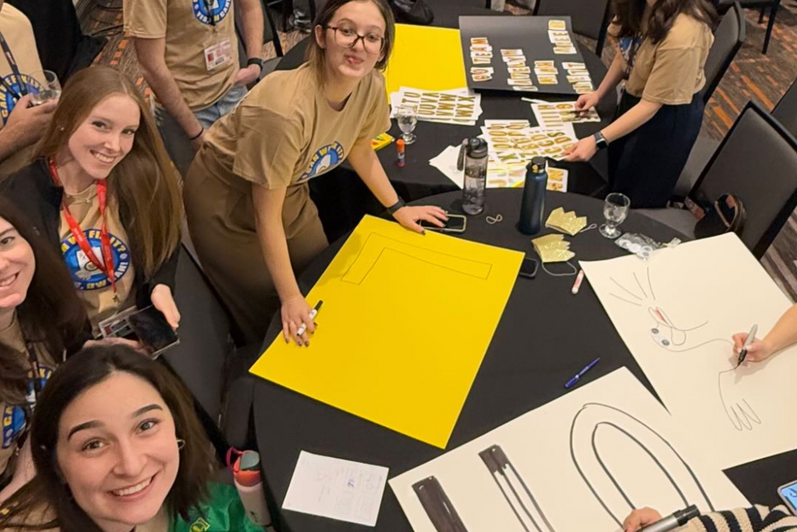 Students smiling making poster signs