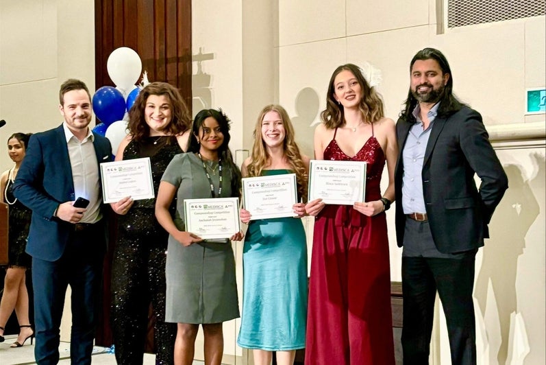 A group of students holding up certificates and smiling