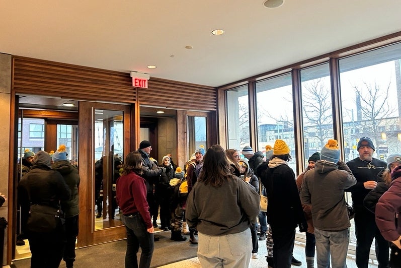 People standing in a line to grab snacks and a beverage in a lobby