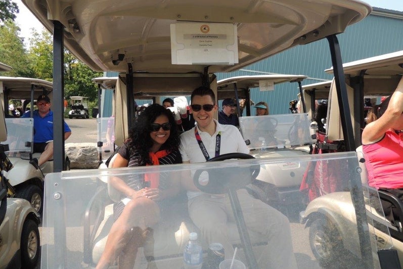 Two people in a golf cart.