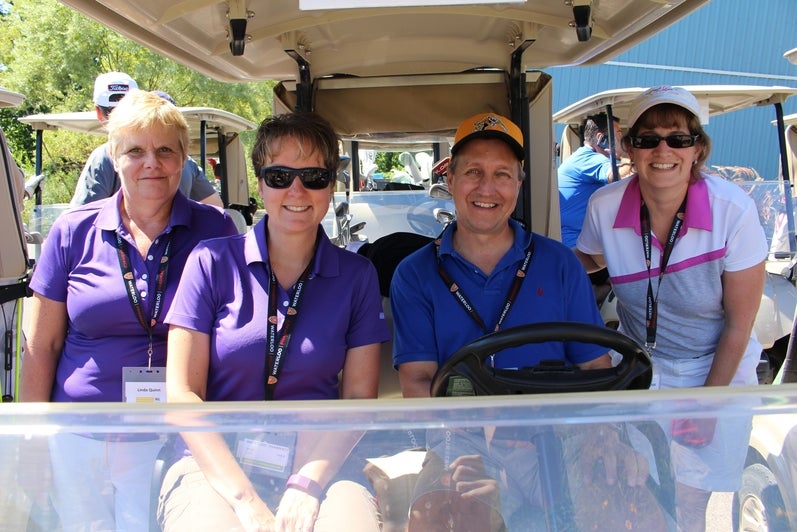 Four golfers in a cart