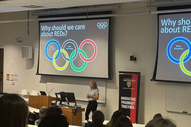 A woman at the front of a classroom giving a lecture