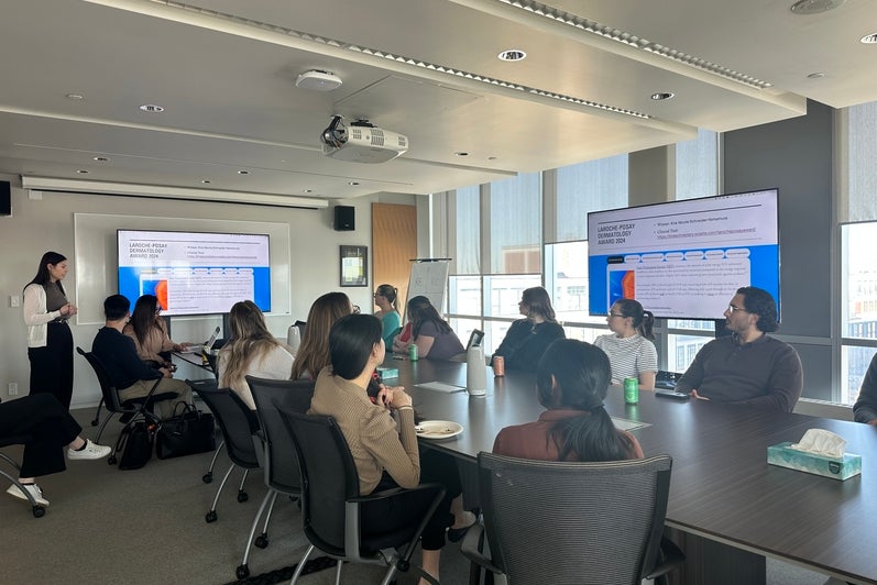 People sitting in a boardroom looking at a large screen