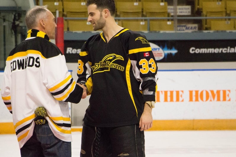 Hockey player shaking hands with director Edwards