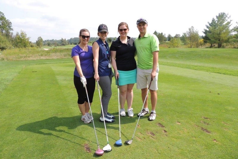 Four alumni on a golf course.