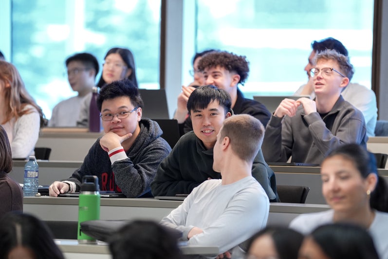 Students smiling in a classroom lecture hall