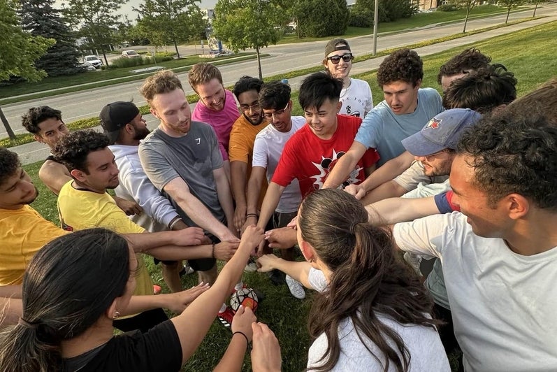 The pharmacy frisbee team gathers for a cheer before the game starts