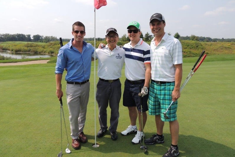 Four alumni on golf course.