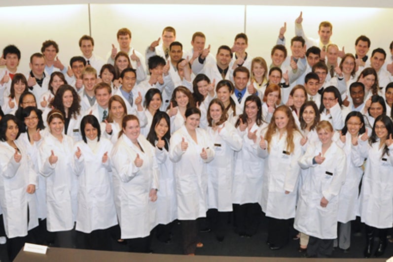 Group of first pharmacy students wearing white coats