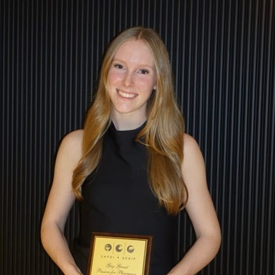A student holding up an award