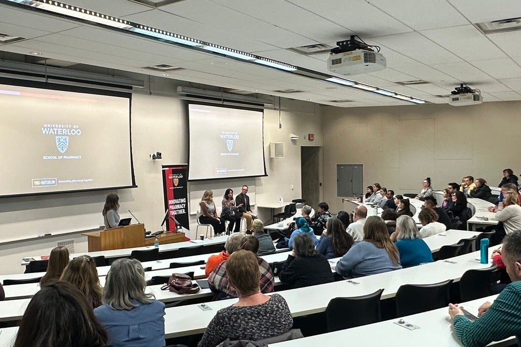 A classroom full of people listening to a presentation