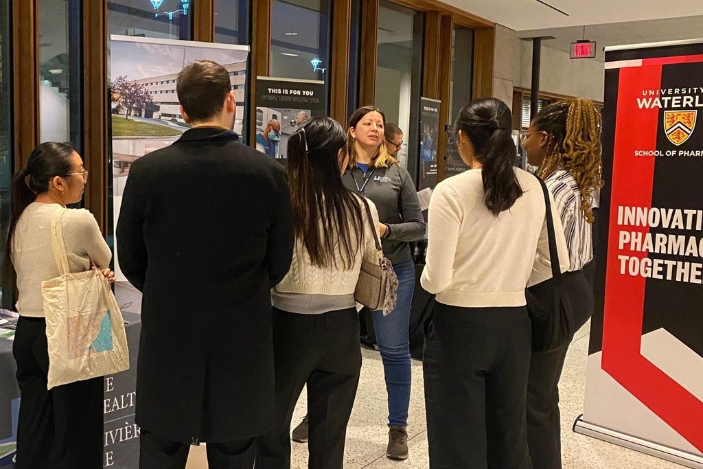 A group of people standing at a booth in discussion