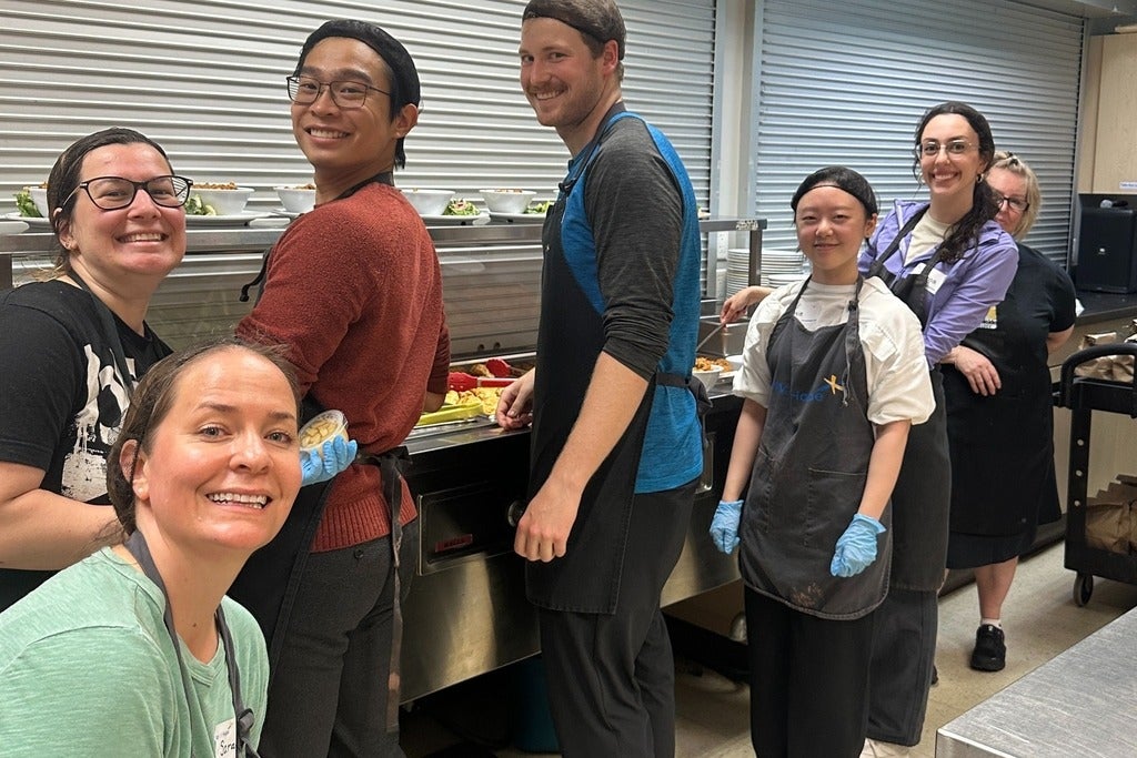 A group of people smiling in aprons and hairnets
