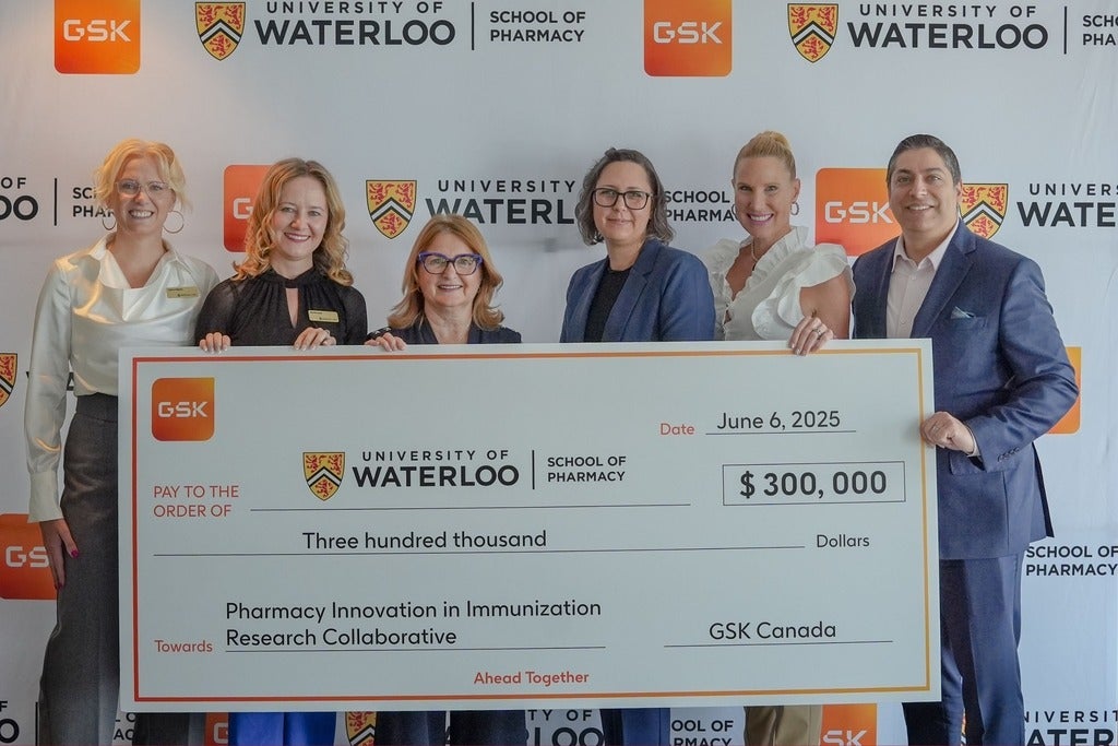 A group of people holding an oversized cheque and smiling