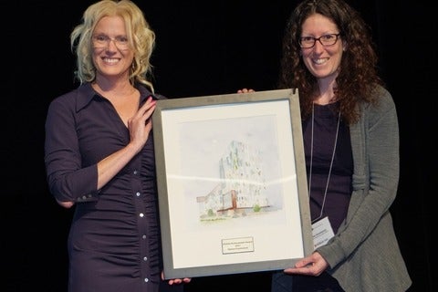 Two people holding an award plaque
