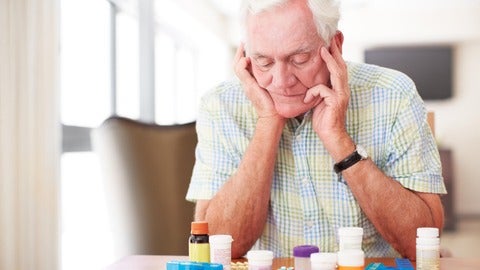 An elderly man looking at medication
