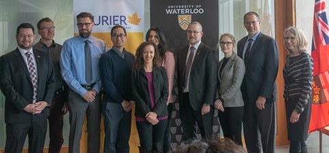Representatives from the University of Waterloo, Laurier University and the Ontario Government standing and smiling
