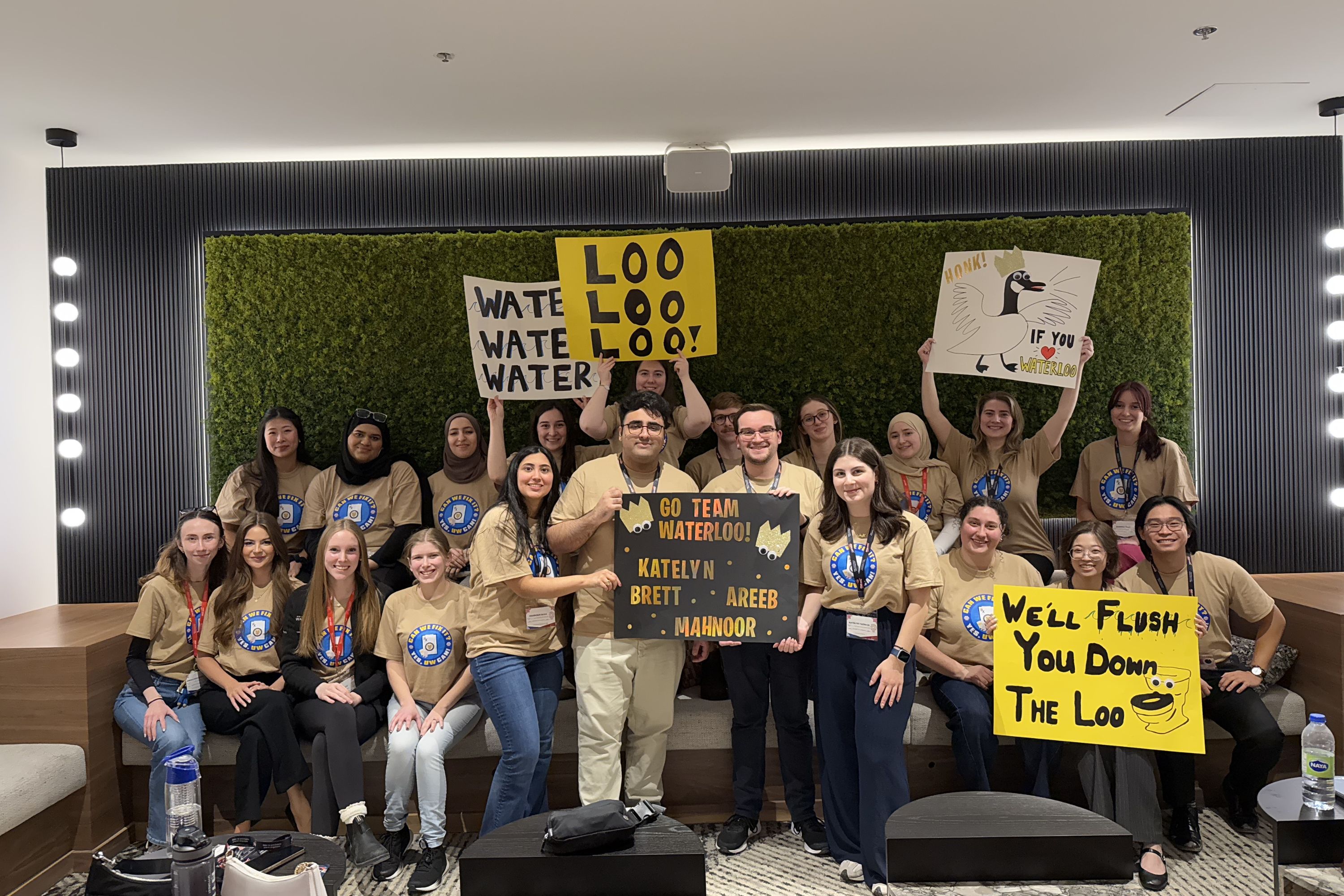 A group of students smiling and holding signs