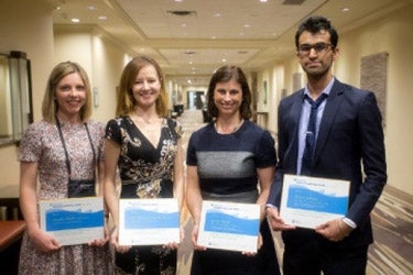 Four award recipients holding certificates