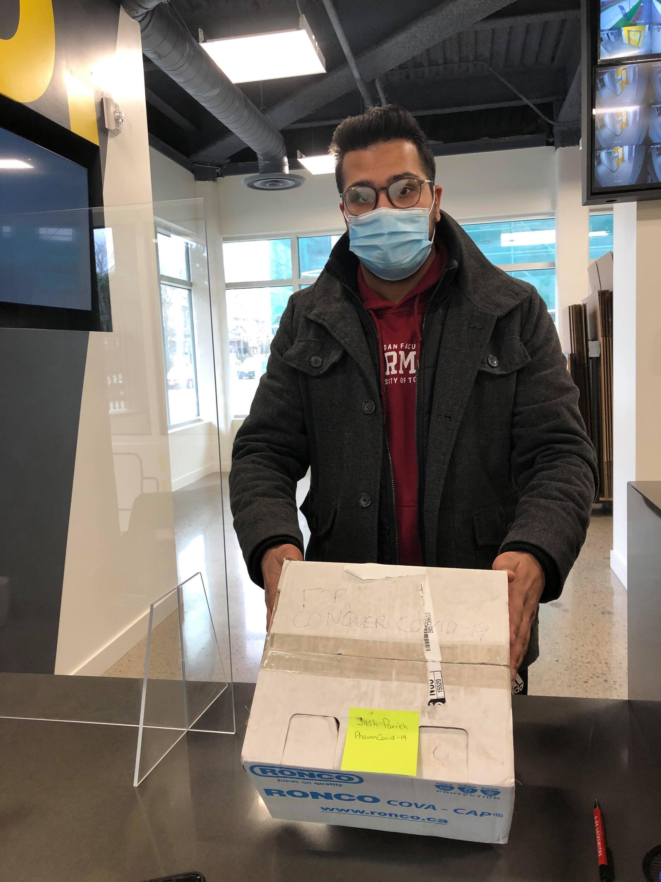 A member of Pharm Against COVID makes a PPE delivery, wearing a mask