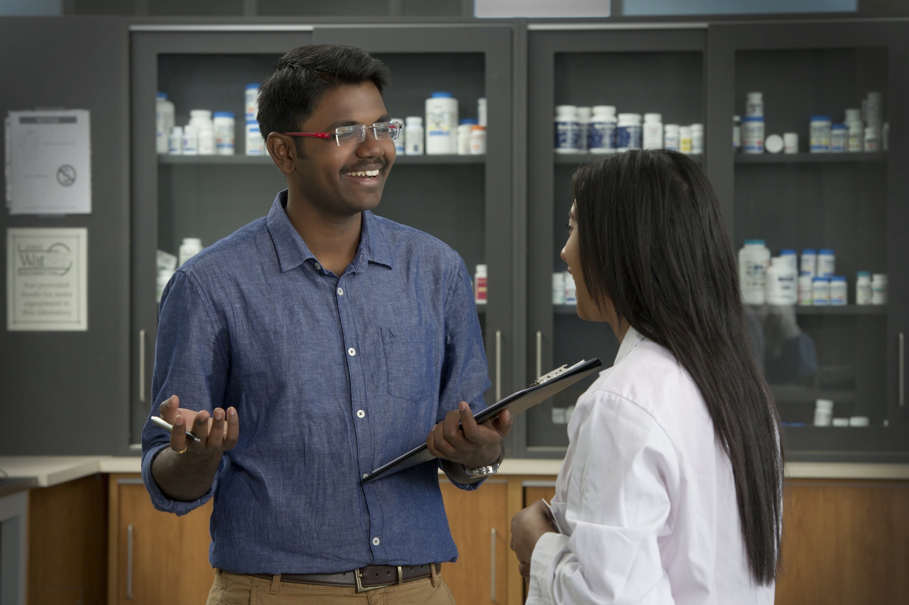 Woman in lab coat discussing with a colleague