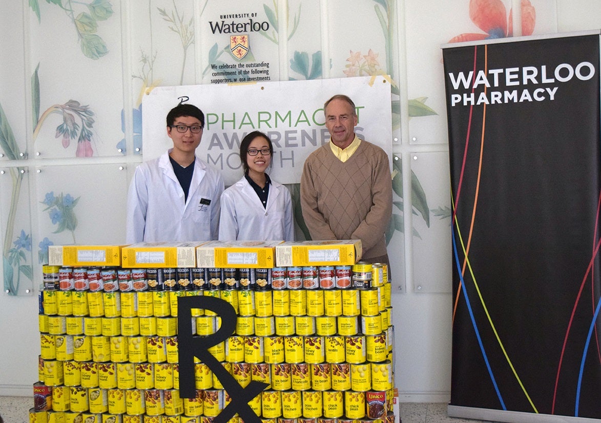 Students and director Dave Edwards stand behind dispensary counter made of cans.