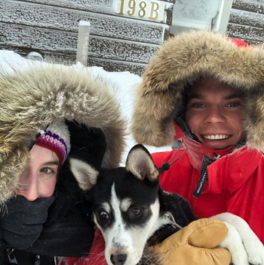 Jenna  and Chris in winter coats holding Rosie their huskky