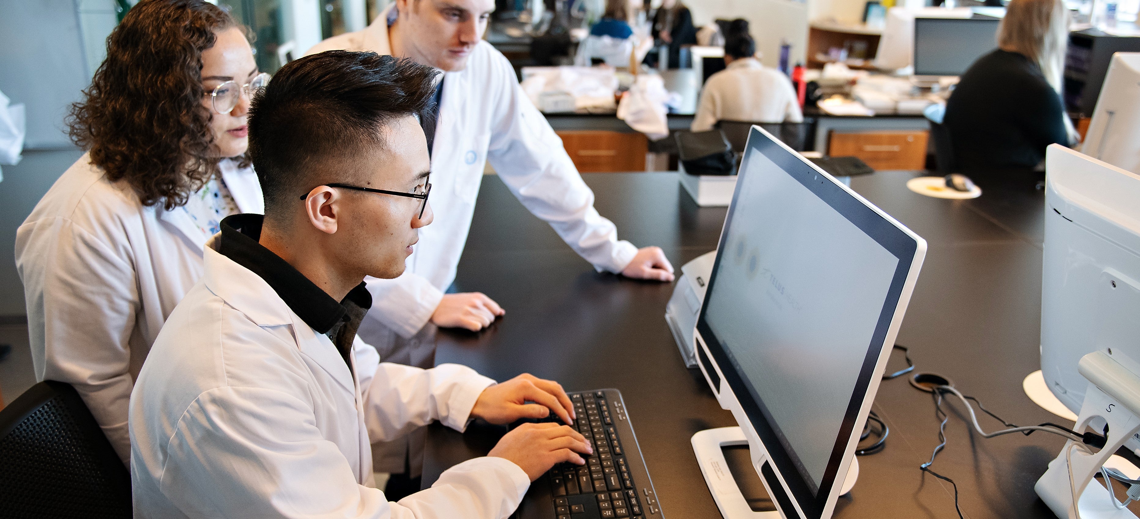 three pharmacy students looking at a computer