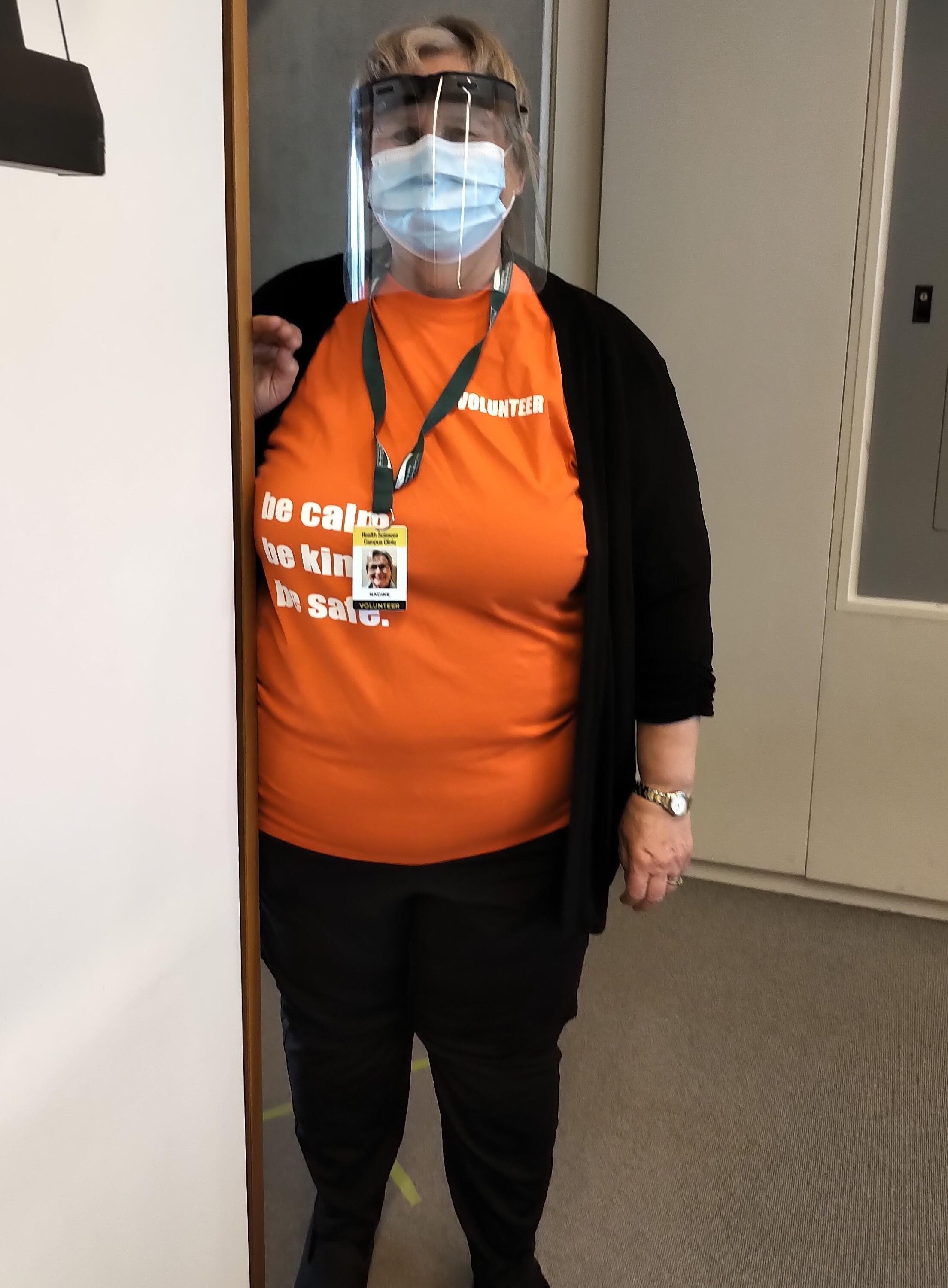 Nadine wearing clinic volunteer shirt and PPE mask