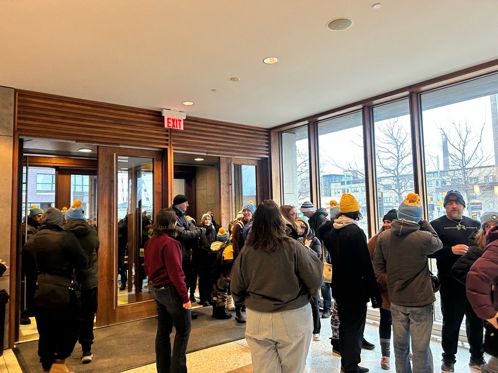 People standing in a line to grab snacks and a beverage in a lobby
