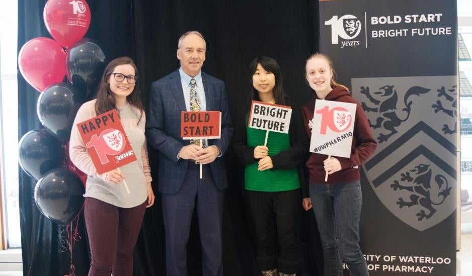 Dave Edward and three students holding bold start, bright future signs.