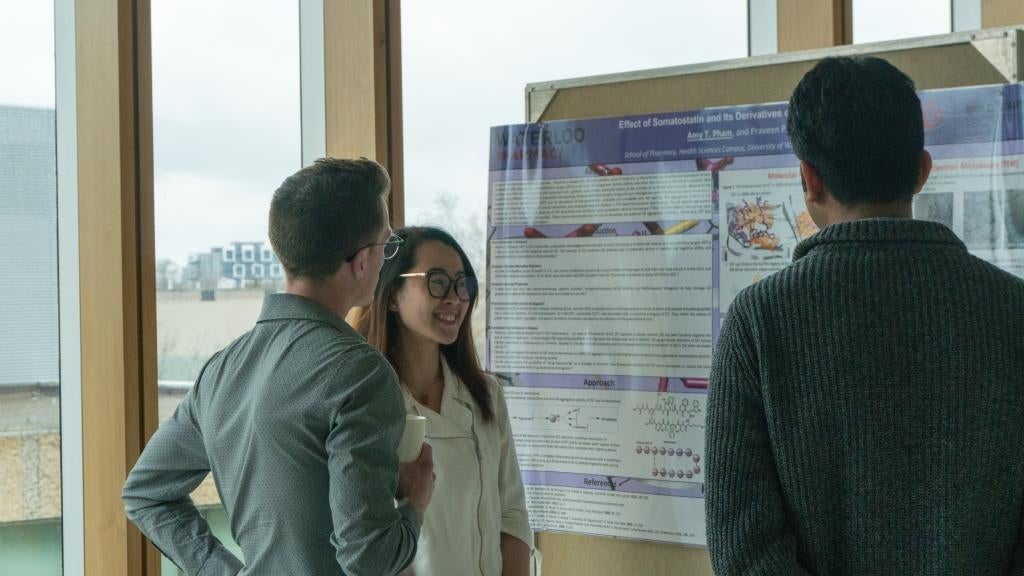 Amy Phan presenting her research to two graduate students