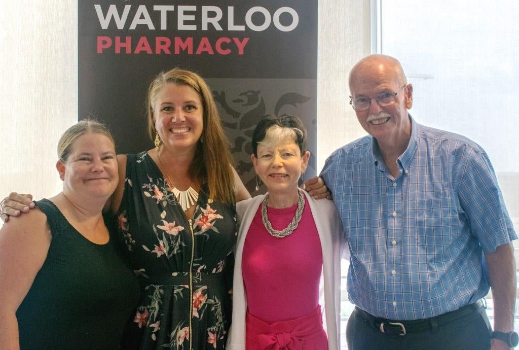 Elaine and her family in front of a Waterloo Pharmacy sign