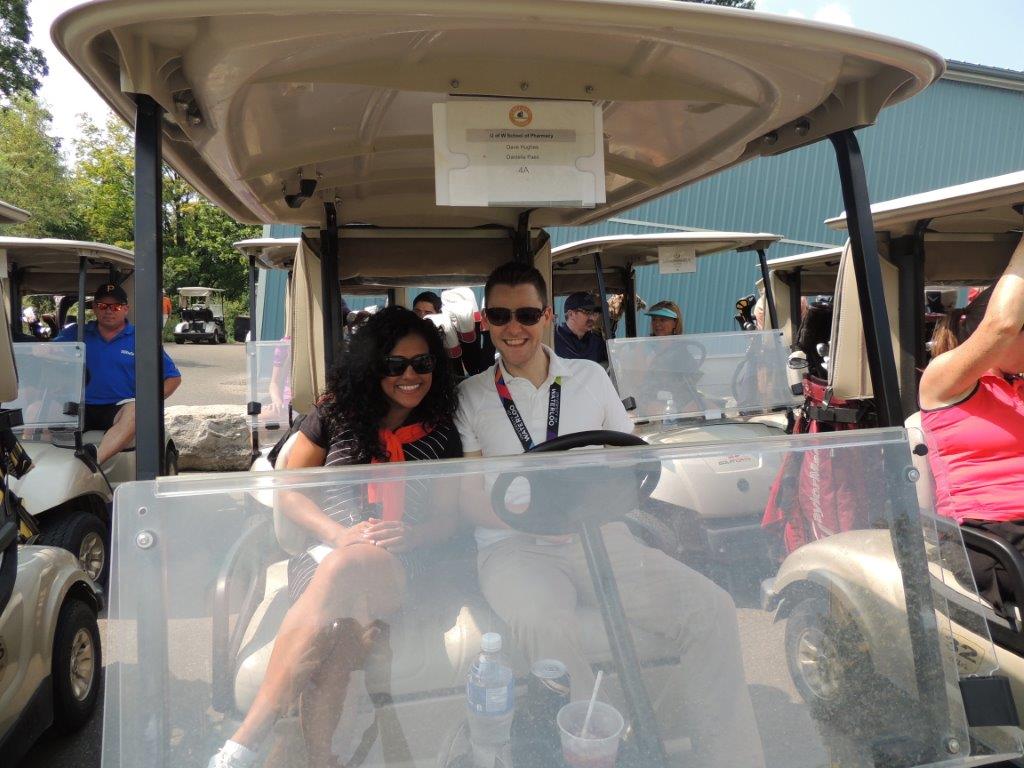 Two people in a golf cart.