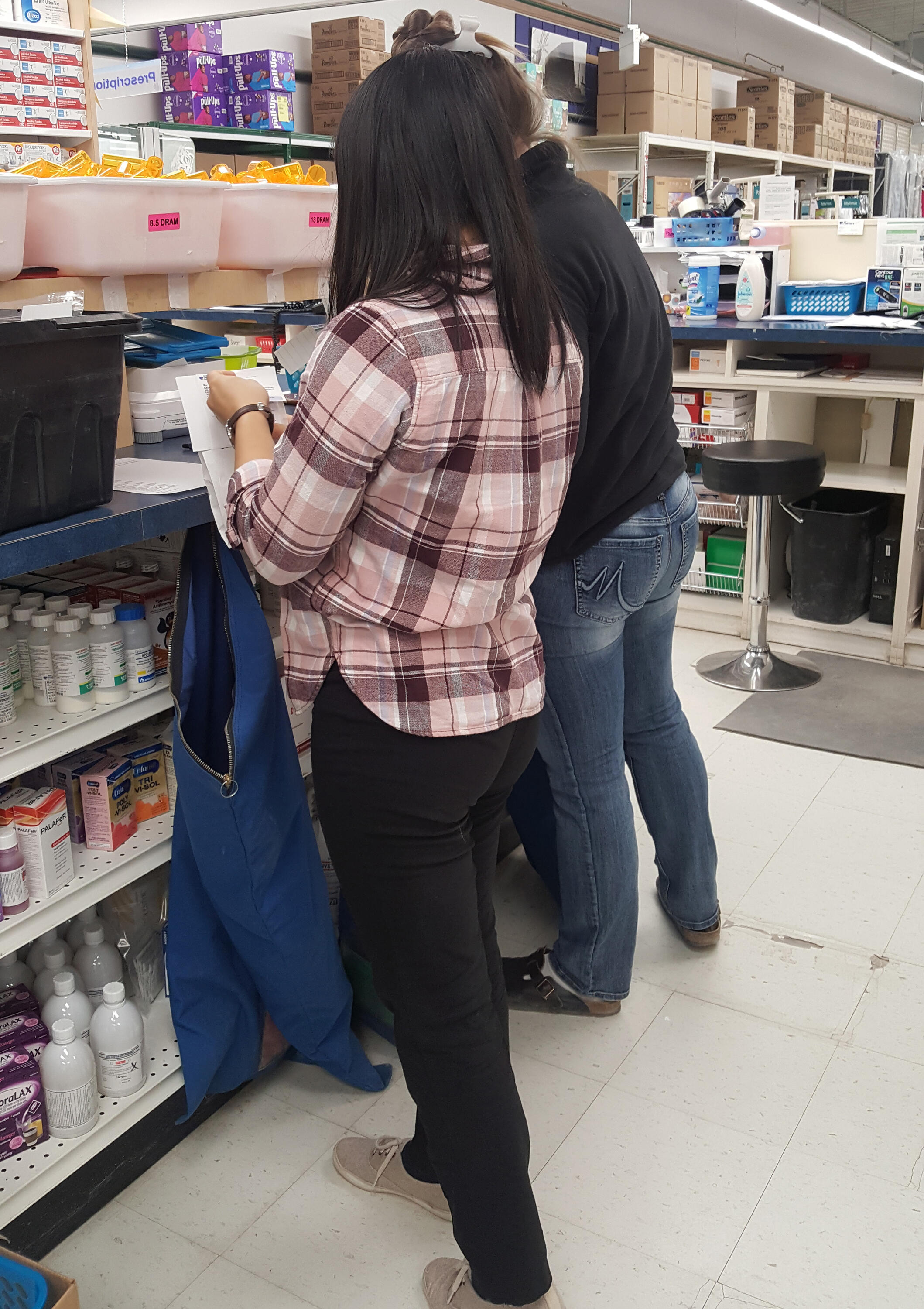 Celine filling a bag with medication at a pharmacy