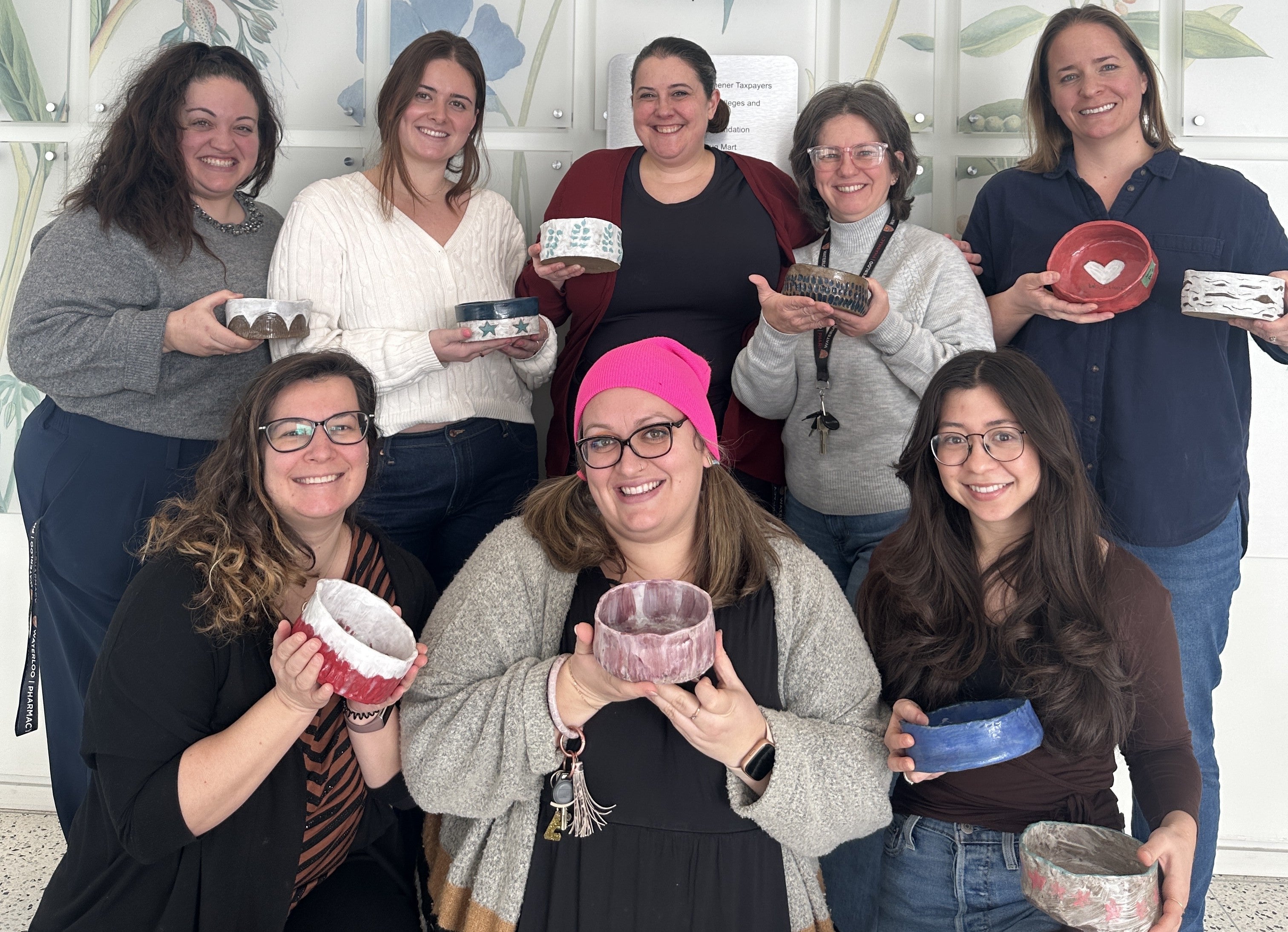 A group of people holding up clay bowls