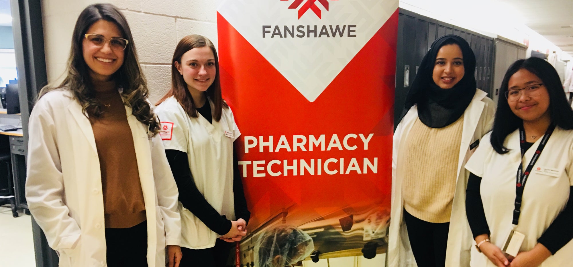 Waterloo Pharmacy students pose with Fanshawe students next to banner that says Pharmacy Technician