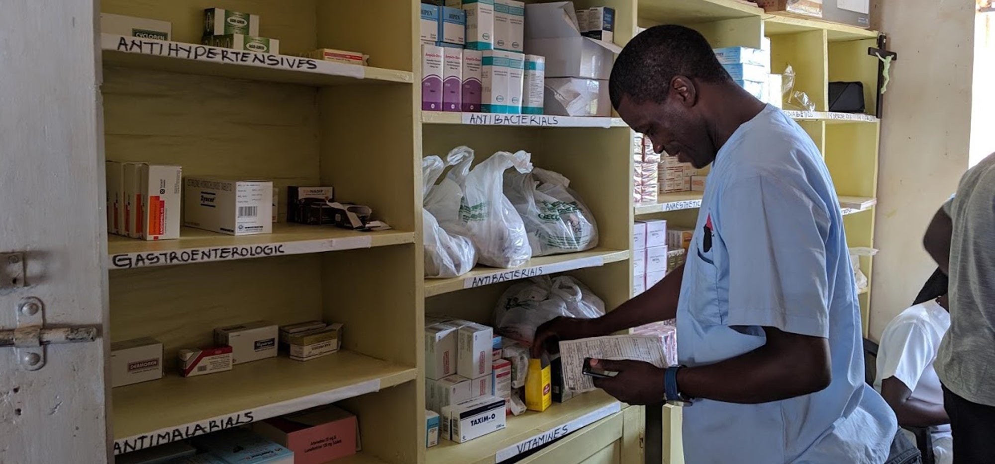 A member of CACHA checking stock on the shelves of the clinic