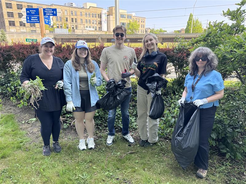 A group of people smiling holding plants