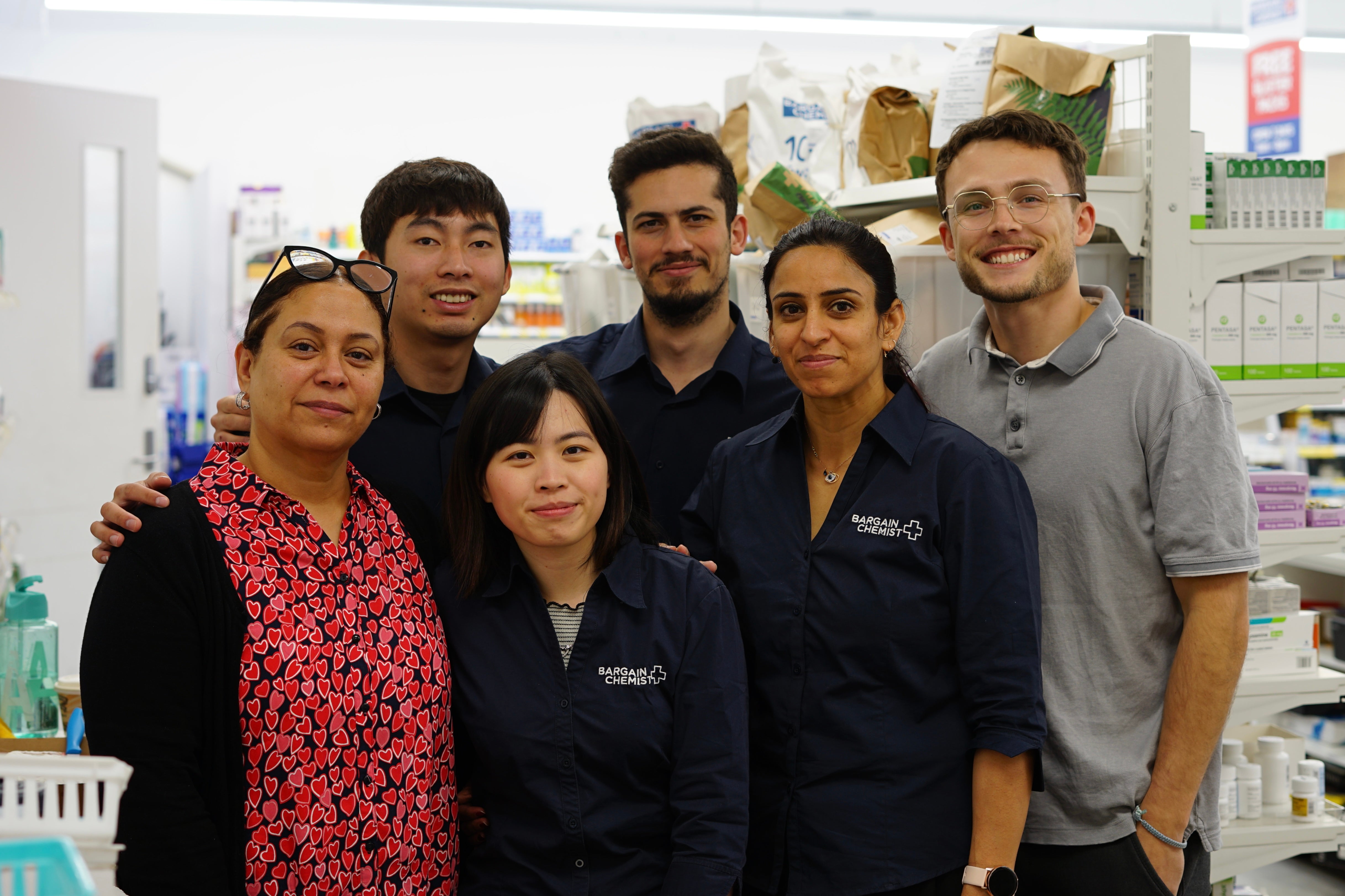 Marcus Yurchuk smiling with the Bargain Chemist pharmacy team in New Zealand