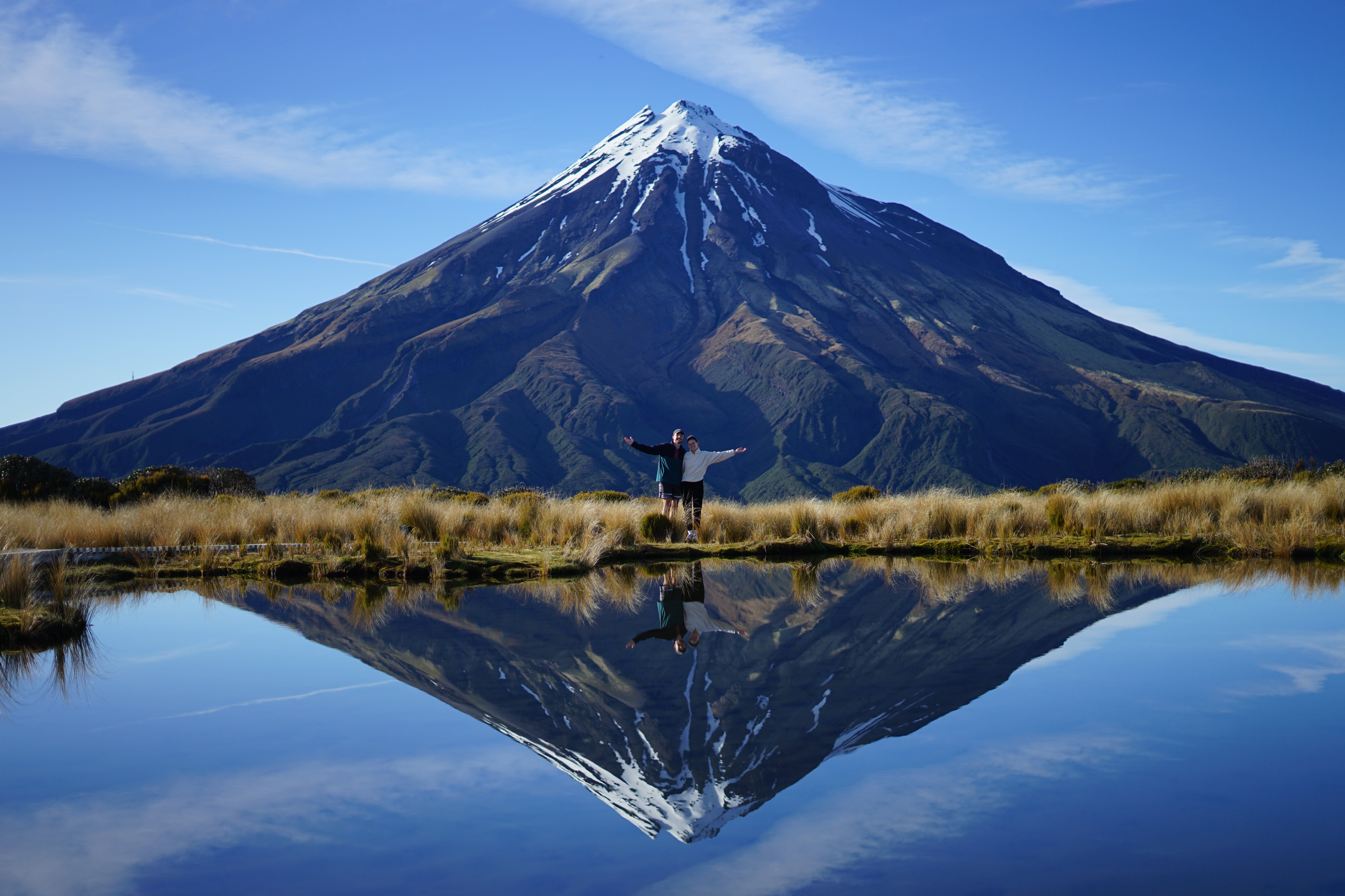 Two people standing in front of a mountain in New Zealand