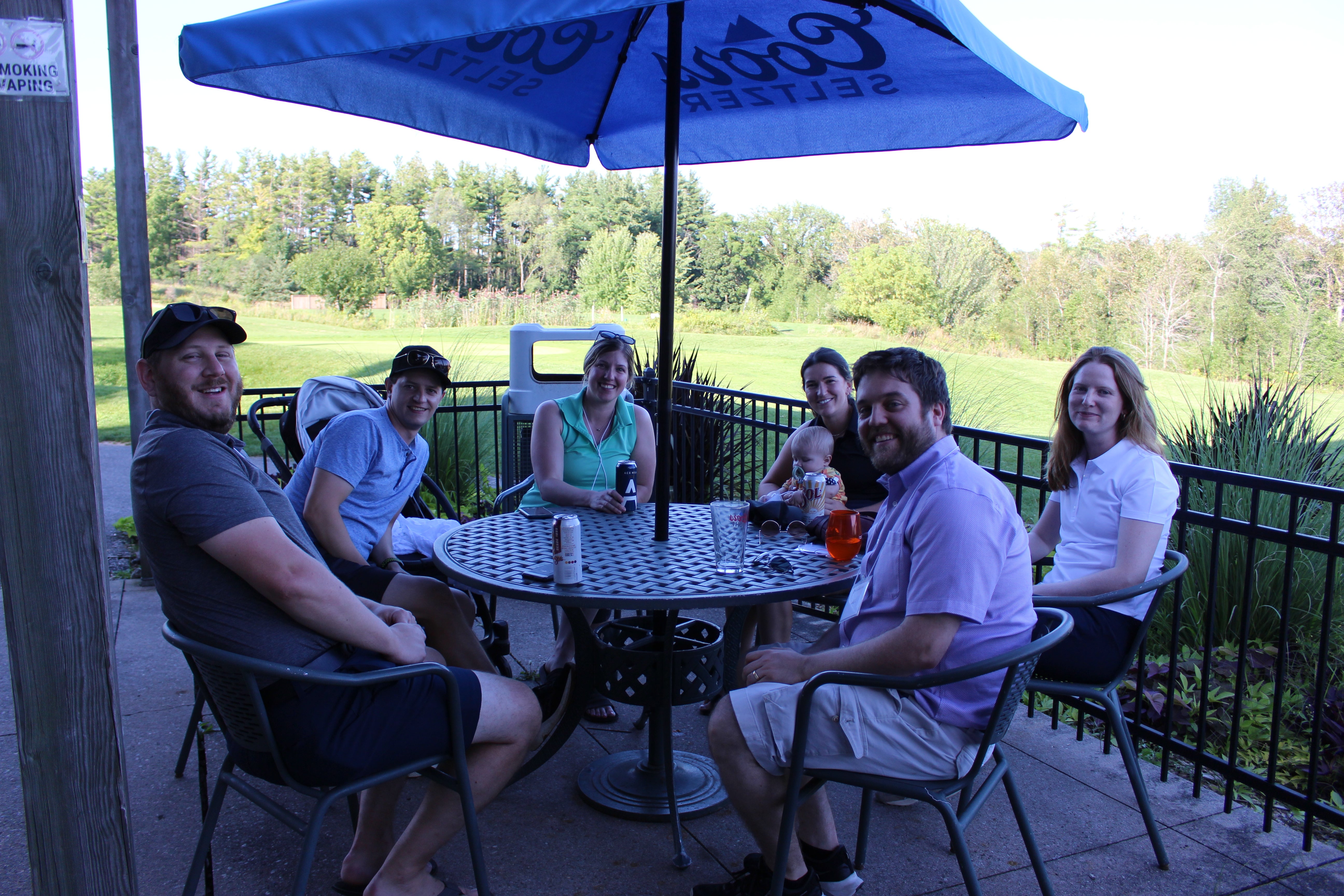 Alumni sitting around a table smiling