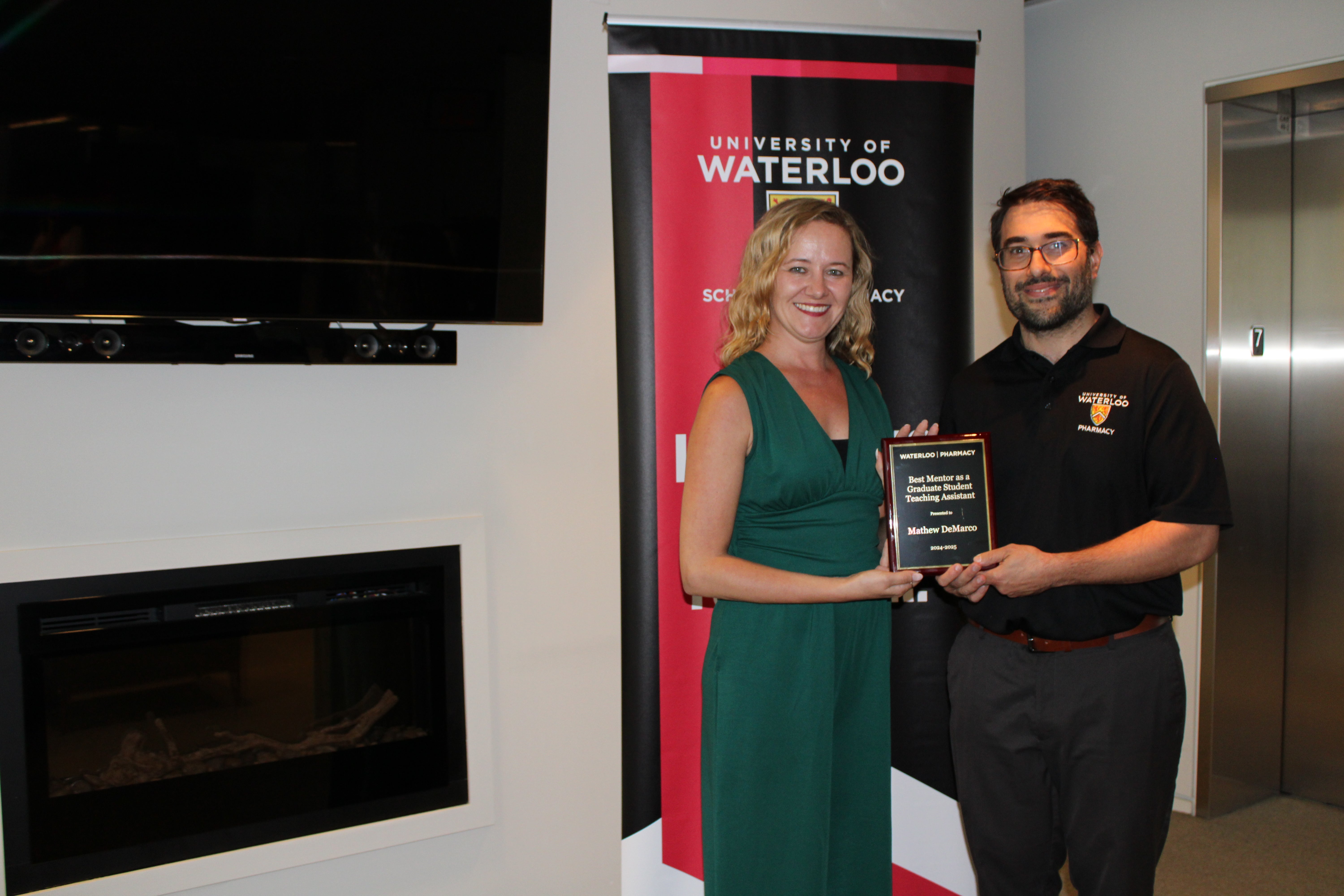 Two people holding an award smiling