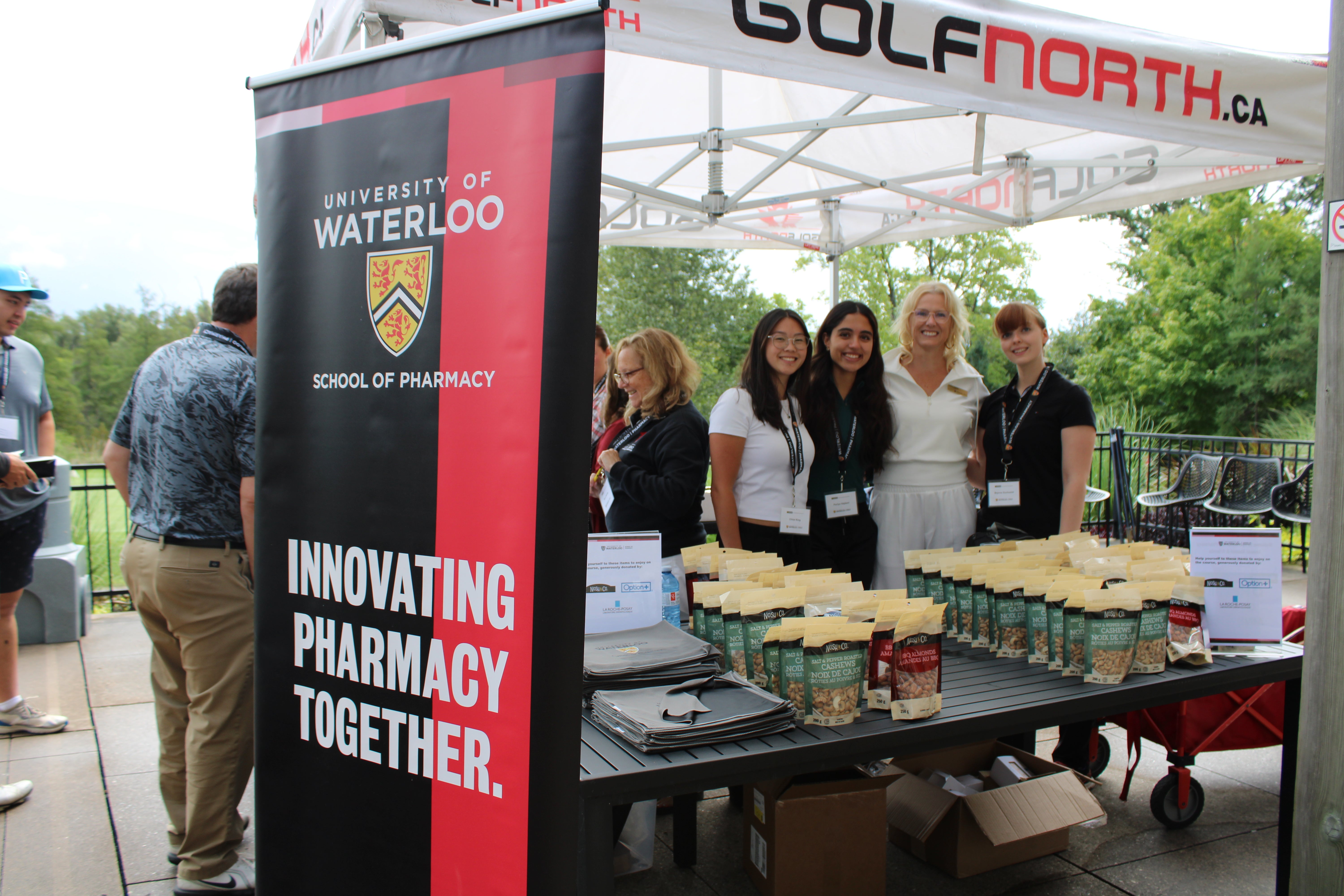 People behind a registration tent smiling