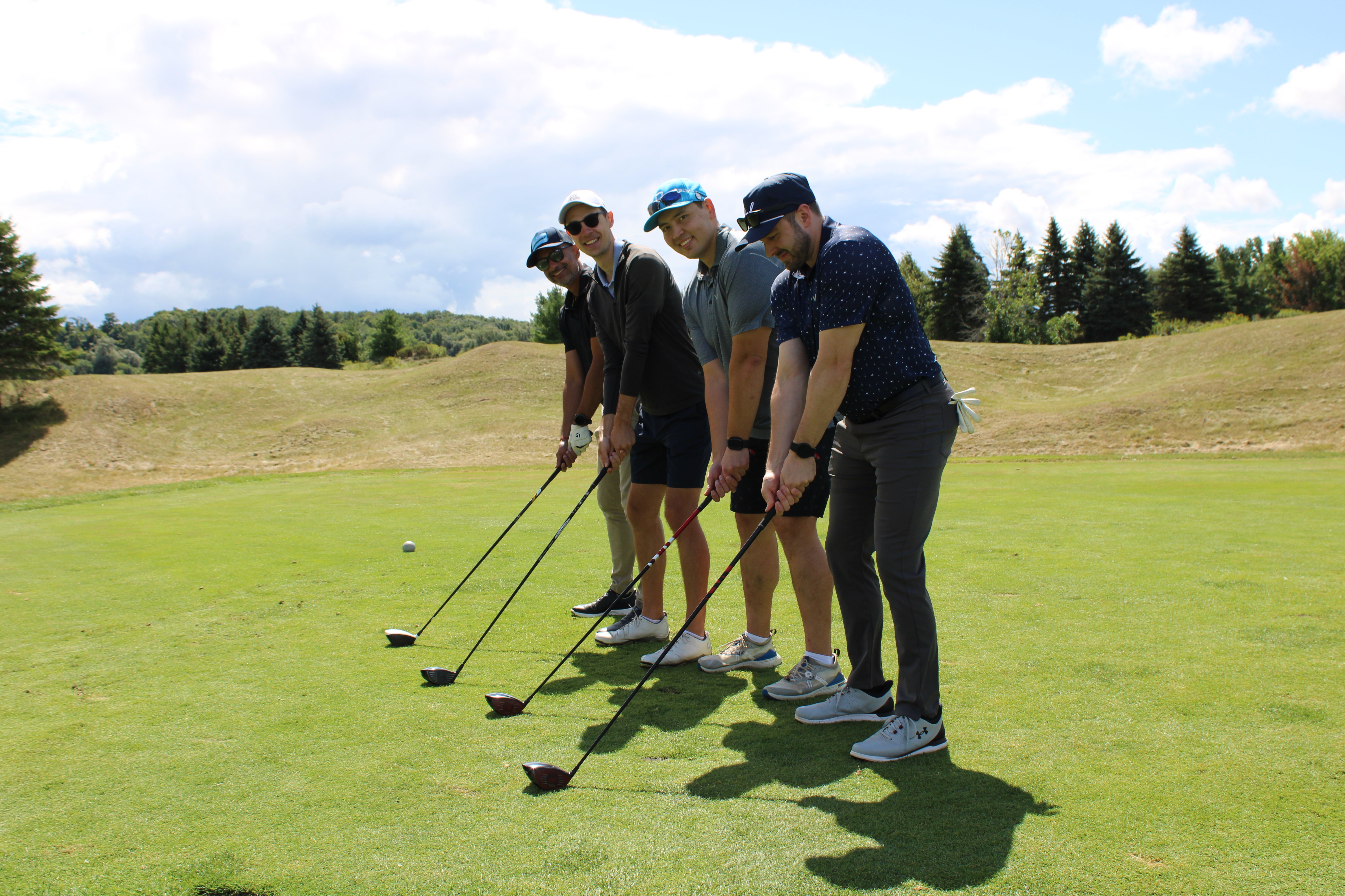 A golf foursome lining up their clubs