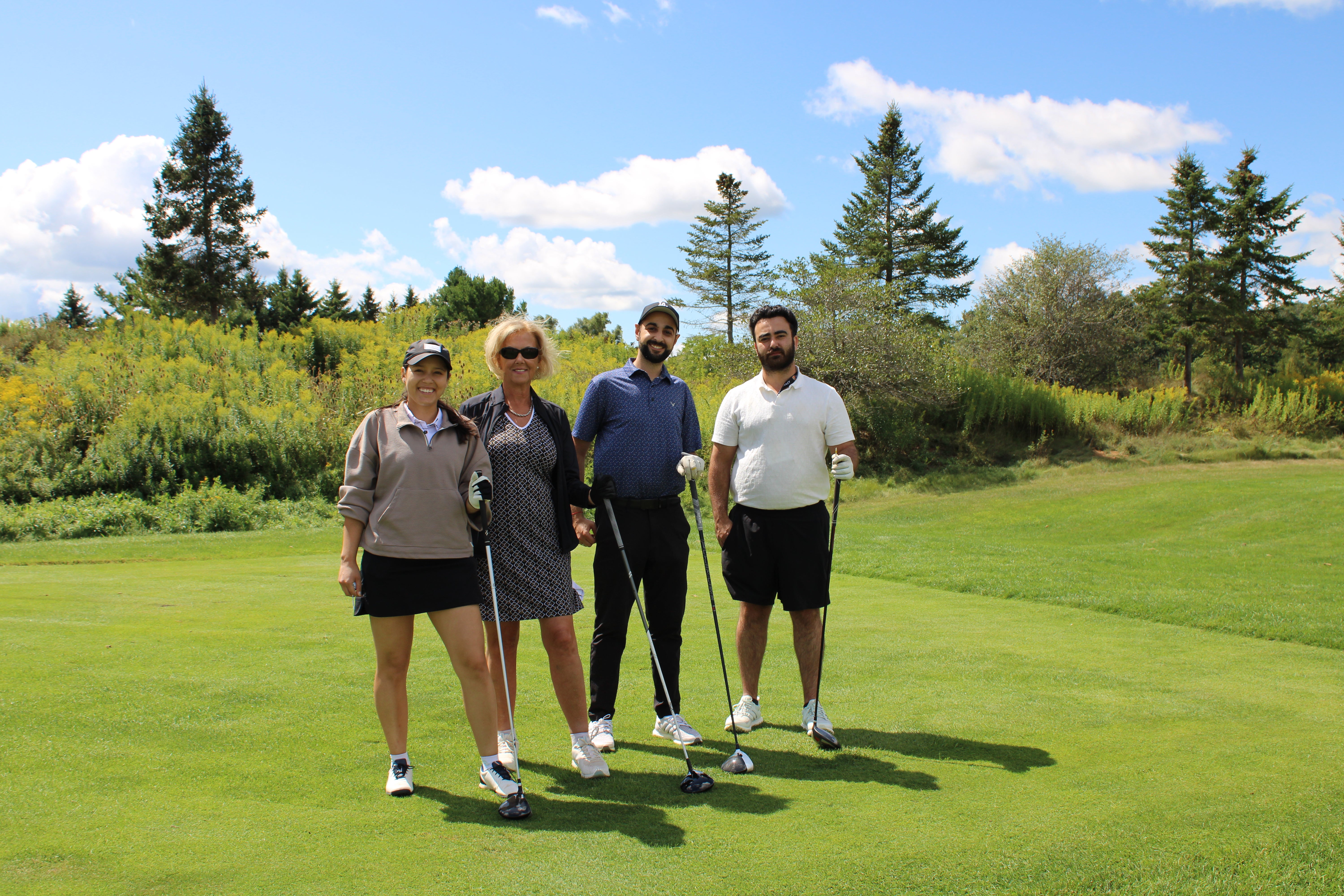 A group of people smiling on the golf course